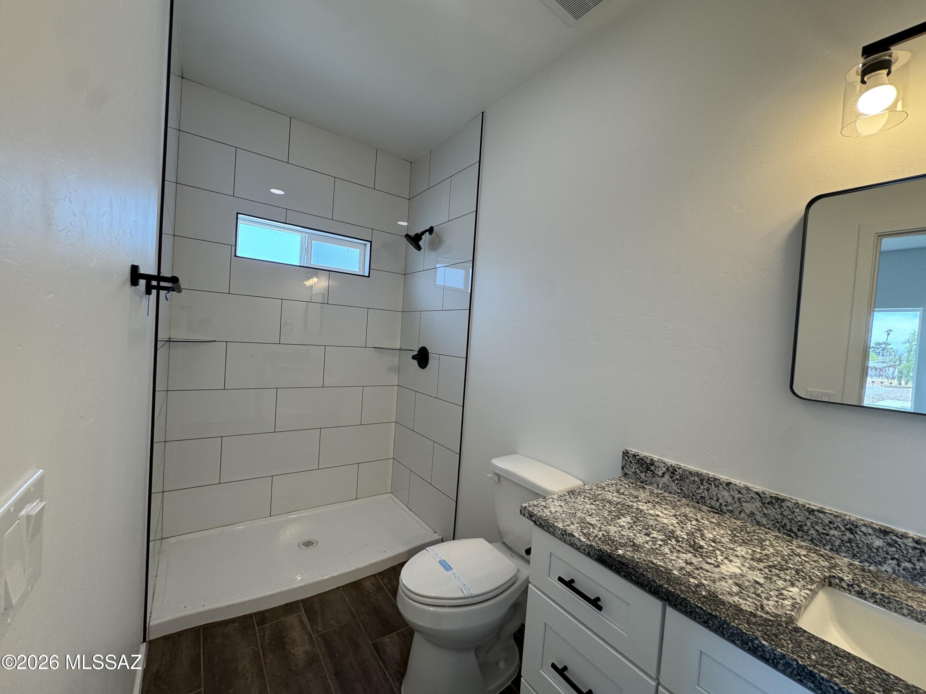 2130 North Ralph Avenue, Unit 1 Tucson, AZ 85712 - Photo 9 of 11 a bathroom with a granite countertop toilet a sink and bathtub