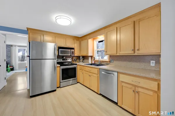a kitchen with stainless steel appliances granite countertop a stove a sink and a refrigerator