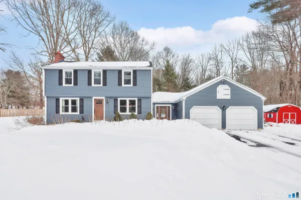 a front view of a house with a yard covered in snow