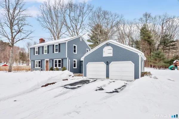 a front view of a house with a yard covered in snow