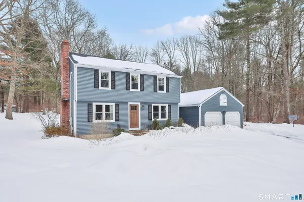 a front view of house with yard covered in snow