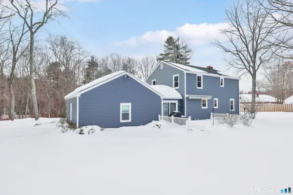 a front view of a house with a yard covered in snow