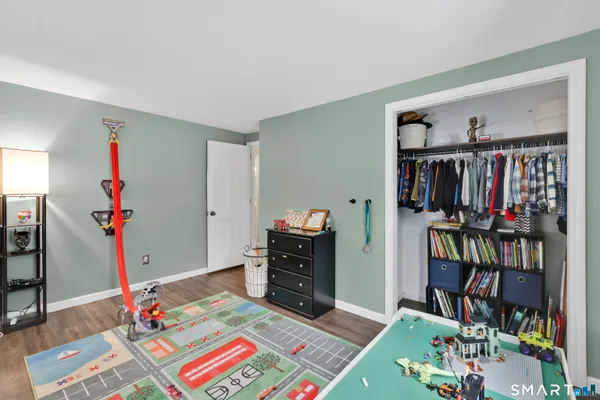 a bedroom with a bed window and wooden floor