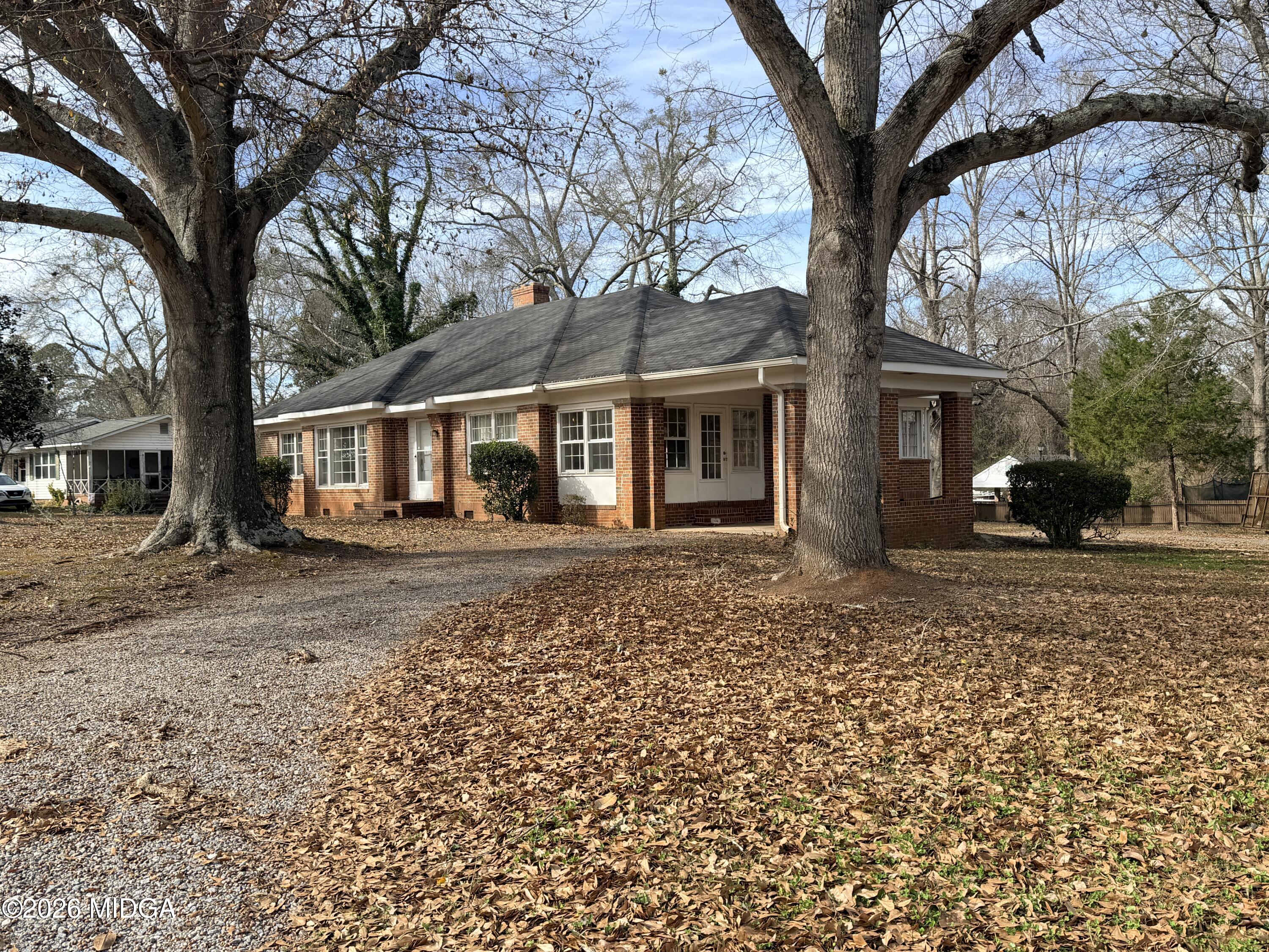 a front view of a house with a tree