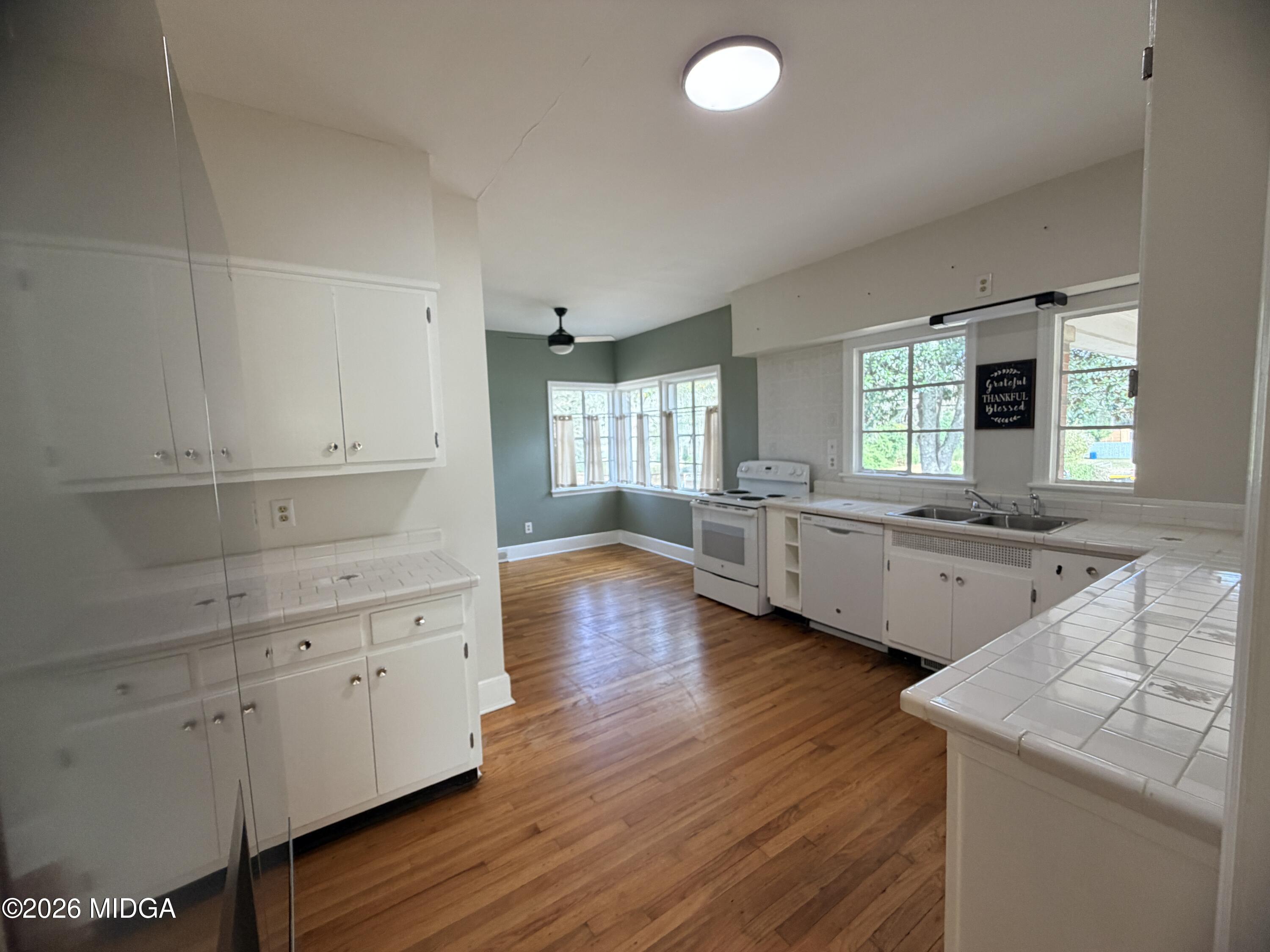 419 West Johnston Street Forsyth, GA 31029 - Photo 11 of 34 a kitchen with hard wood floors and white appliances