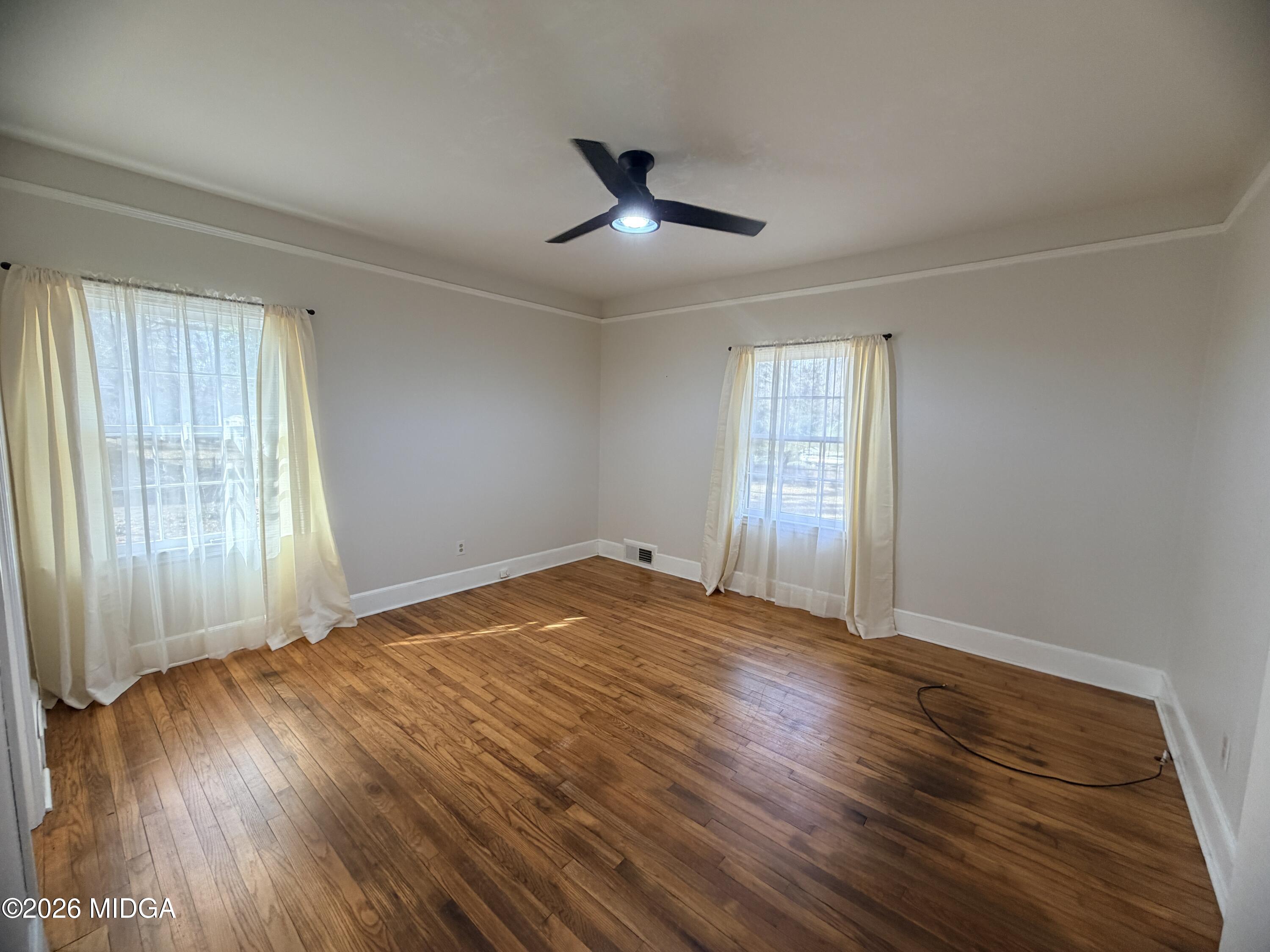 419 West Johnston Street Forsyth, GA 31029 - Photo 16 of 34 an empty room with wooden floor and windows