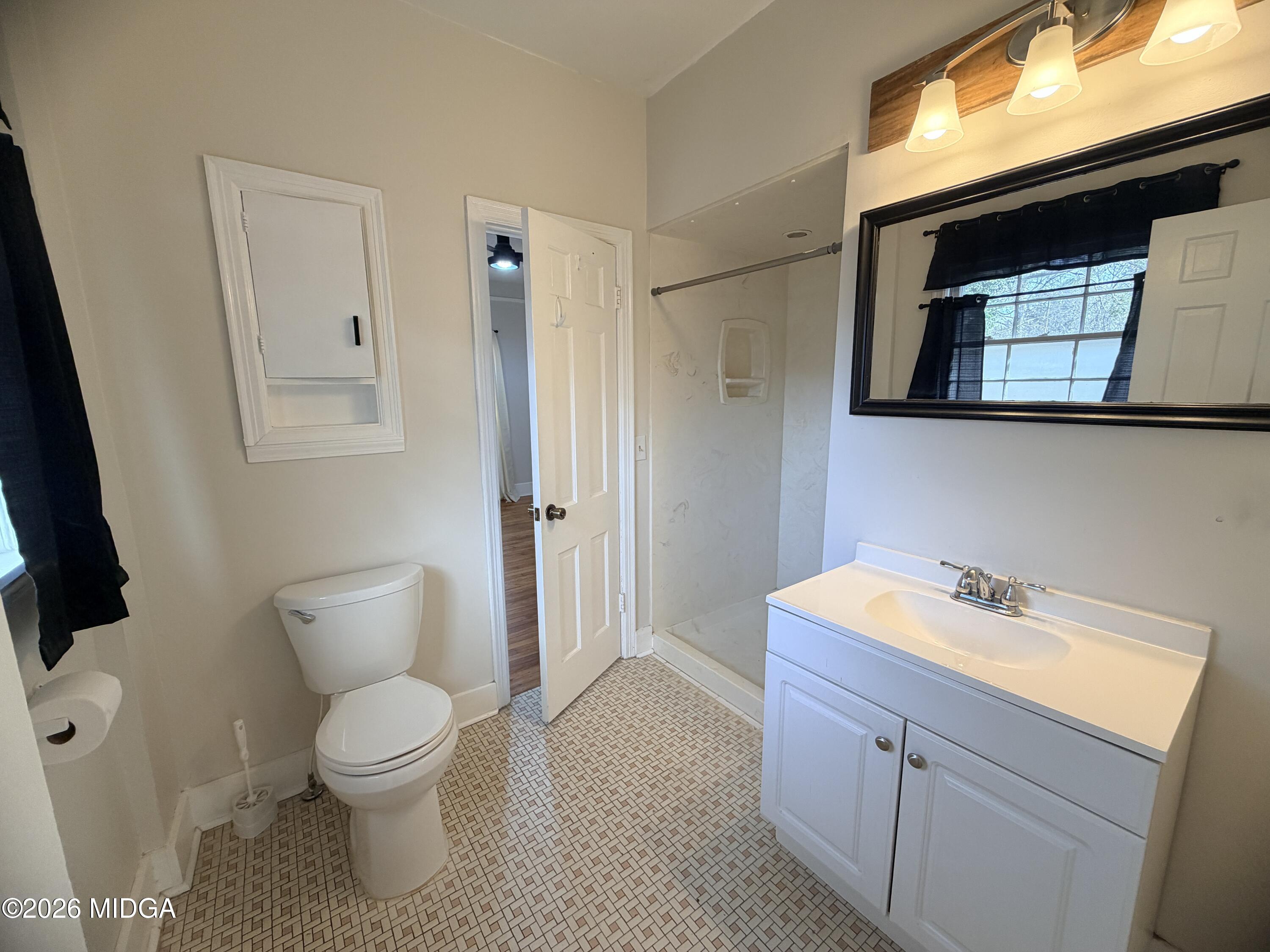 419 West Johnston Street Forsyth, GA 31029 - Photo 18 of 34 a bathroom with a toilet sink and mirror