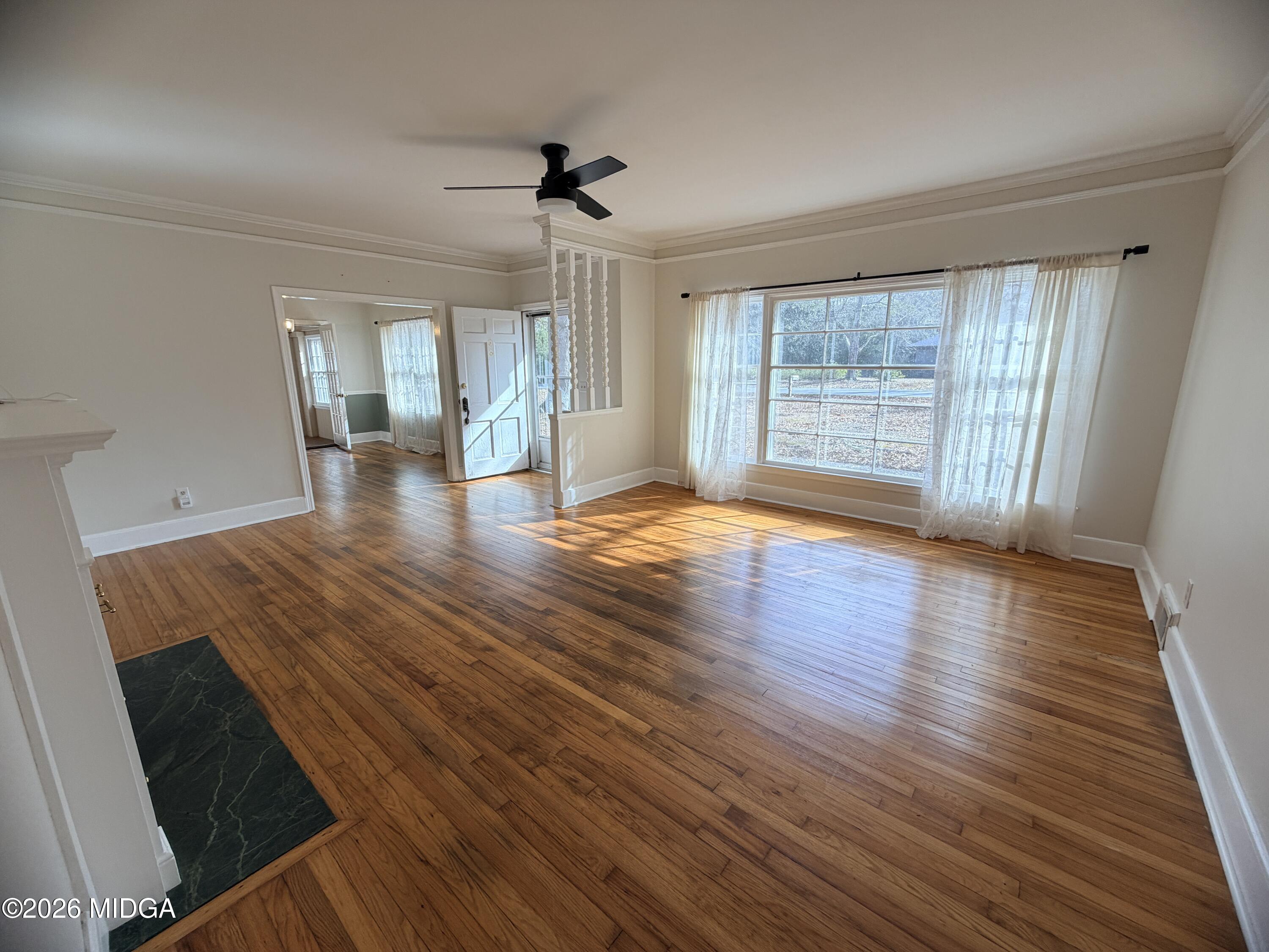 419 West Johnston Street Forsyth, GA 31029 - Photo 8 of 34 a view of an empty room with wooden floor and a window