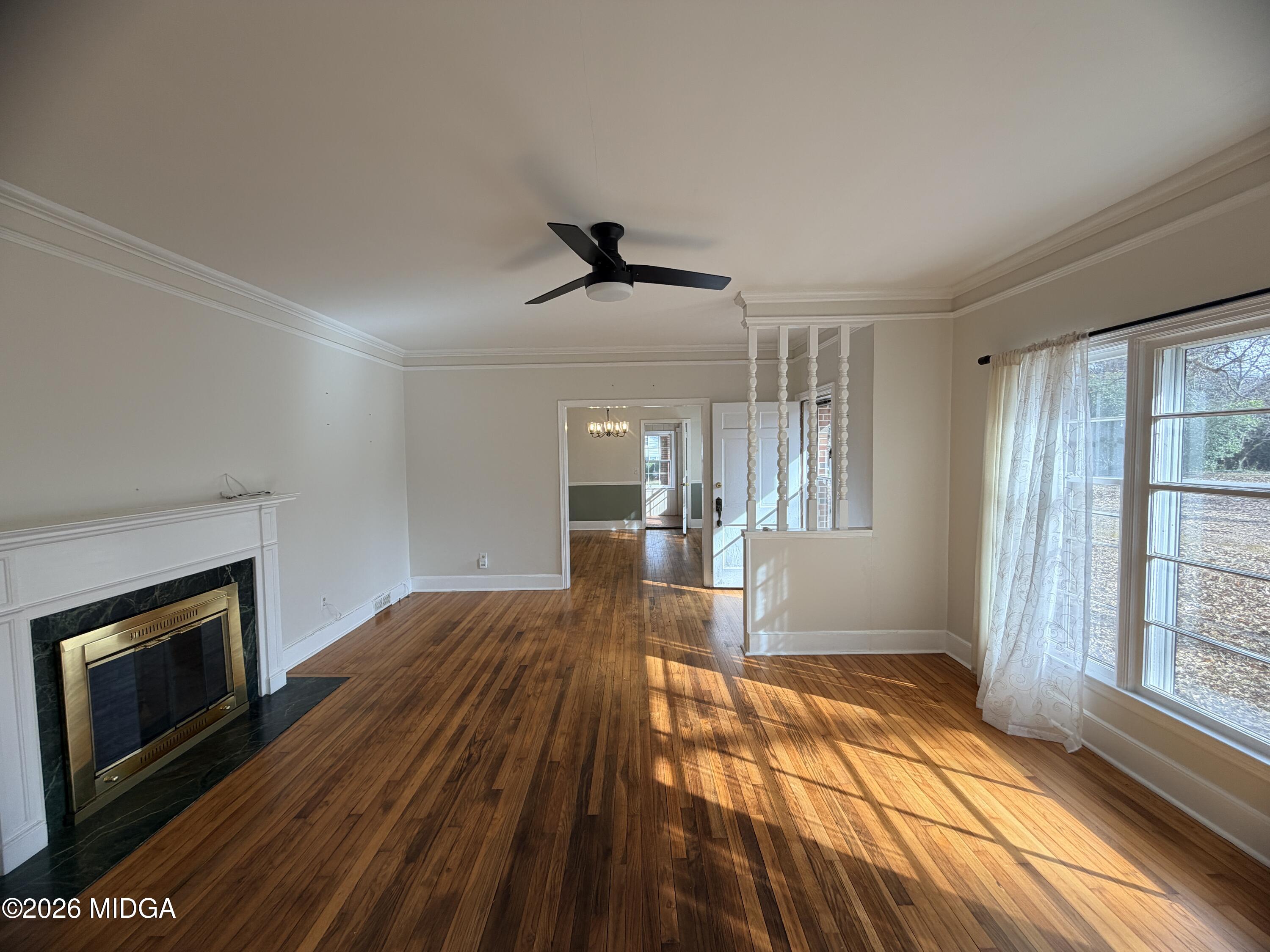 419 West Johnston Street Forsyth, GA 31029 - Photo 9 of 34 a view of empty room with wooden floor and fireplace