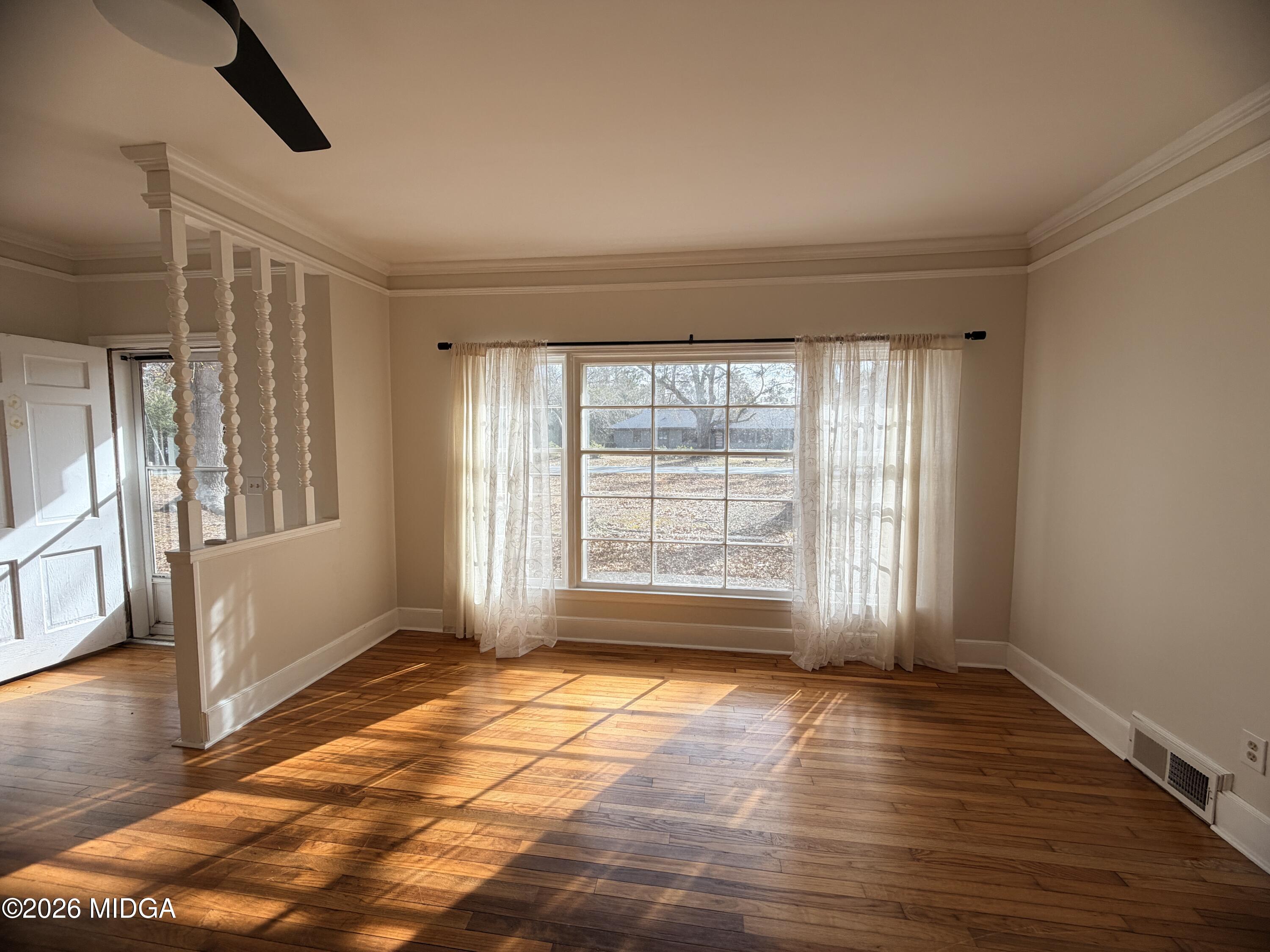 419 West Johnston Street Forsyth, GA 31029 - Photo 10 of 34 a view of an empty room with a window and wooden floor