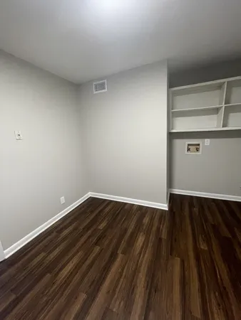 a view of an empty room with wooden floor