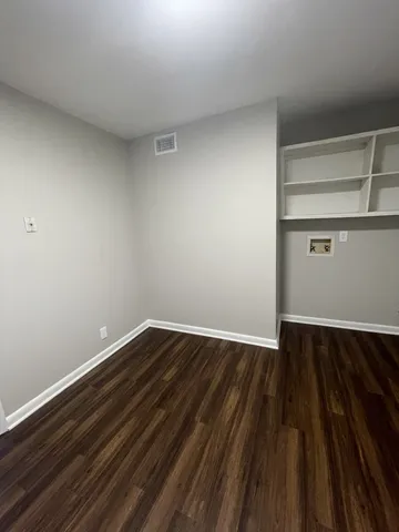 a view of an empty room with wooden floor