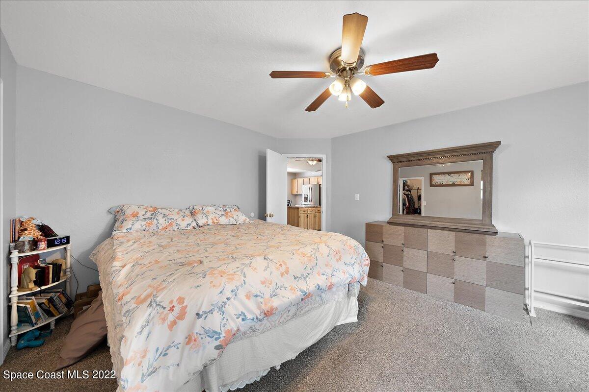 6165 Corning Road Cocoa, FL 32927 - Photo 18 of 44 a bedroom with a bed and a chandelier