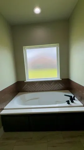 a bathroom with a bathtub and a window