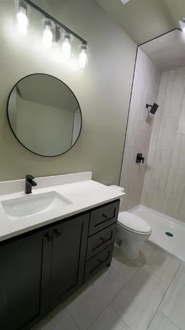 a bathroom with a sink a toilet and shower
