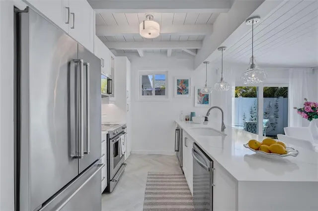 a kitchen with stainless steel appliances granite countertop a sink a stove and a refrigerator