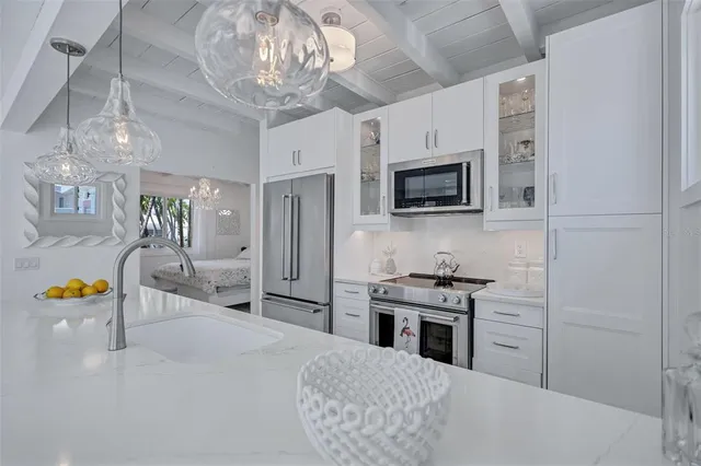 a kitchen with stainless steel appliances kitchen island granite countertop a refrigerator and a stove top oven