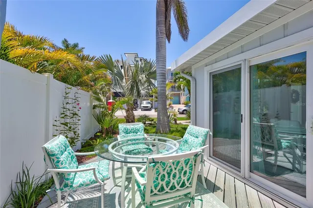 a patio with table and chairs and potted plants