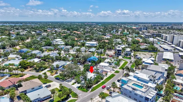 an aerial view of residential houses with outdoor space and trees