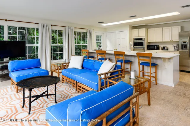 a living room with furniture kitchen view and a large window