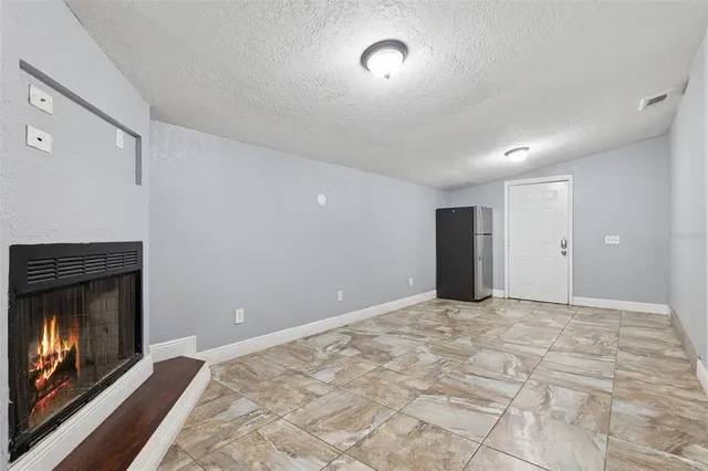a view of empty room with window and fireplace