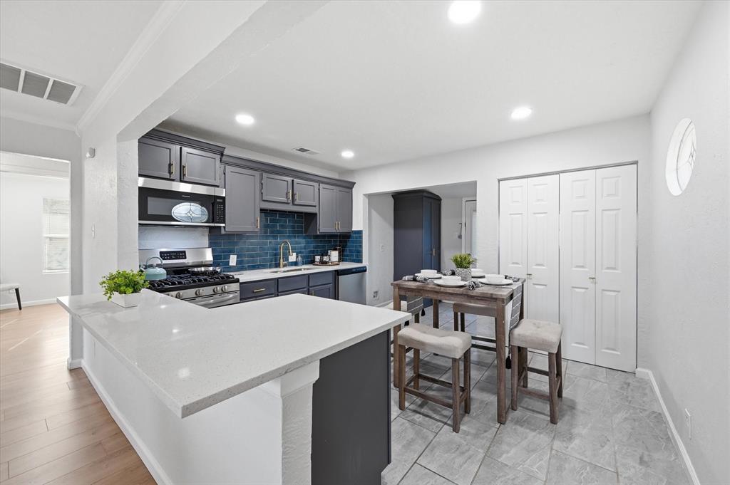 330 West Vinyard Road Duncanville, TX 75137 - Photo 6 of 20 a kitchen with stainless steel appliances kitchen island granite countertop a sink and a refrigerator
