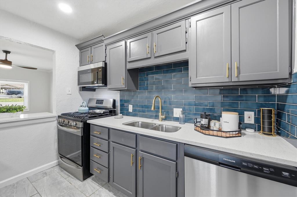 330 West Vinyard Road Duncanville, TX 75137 - Photo 7 of 20 a kitchen with stainless steel appliances granite countertop a sink stove and cabinets