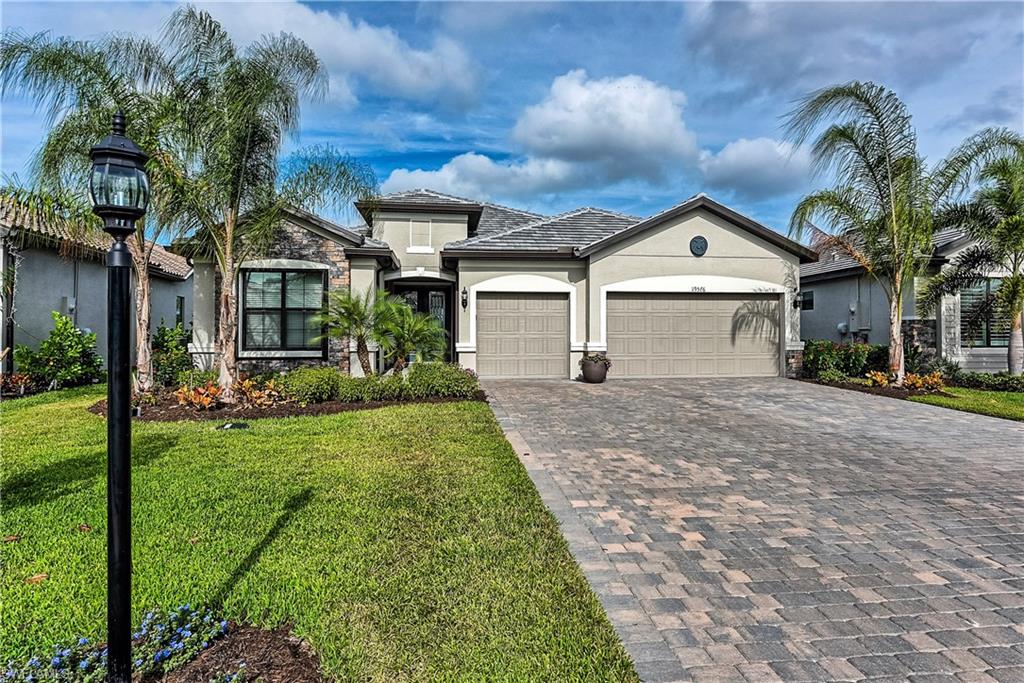 19576 The Pl Boulevard Estero, FL 33928 - Photo 1 of 35 a front view of a house with a yard and garage