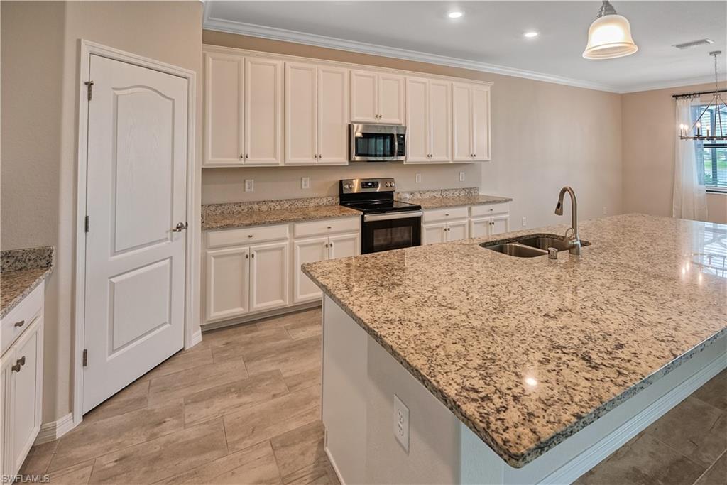 19576 The Pl Boulevard Estero, FL 33928 - Photo 6 of 35 a kitchen with stainless steel appliances granite countertop a sink stove and refrigerator