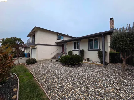 a backyard of a house with table and chairs