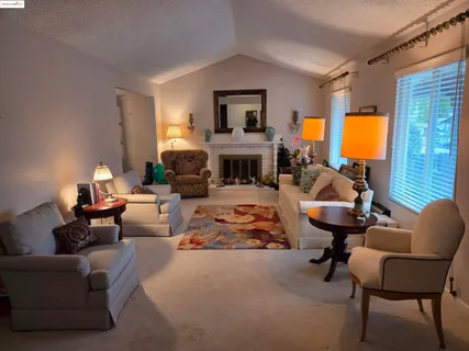a living room with furniture fireplace and a large window