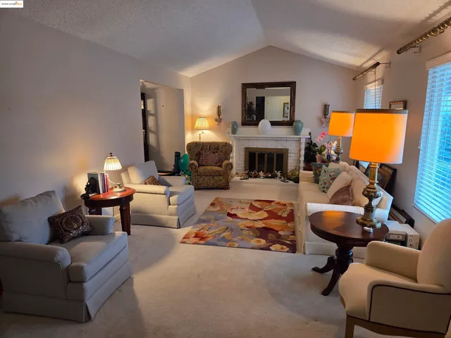 a living room with furniture a fireplace and a flat screen tv