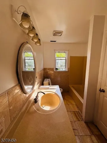 an empty room with a washing machine and mirror