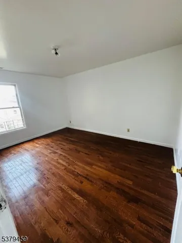 a view of room with wooden floor and white walls