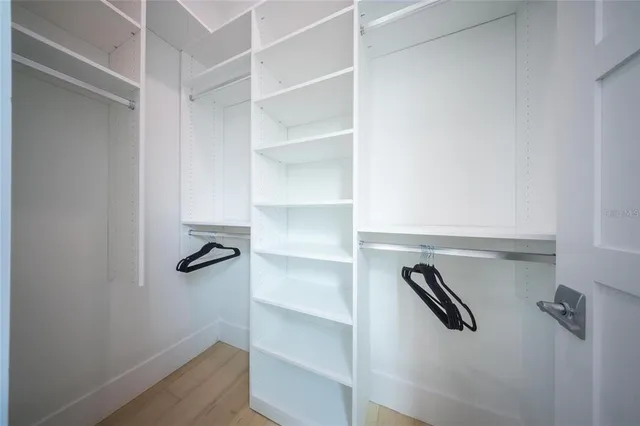 a view of walk in closet with empty racks