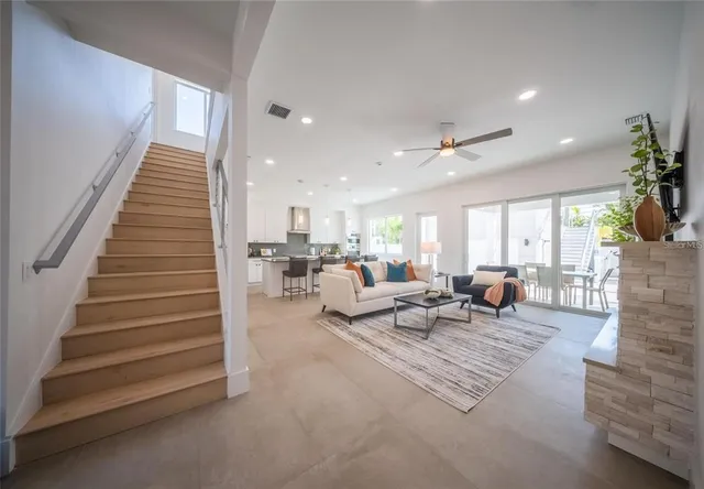a living room with stainless steel appliances kitchen island granite countertop a couch and a view of living room