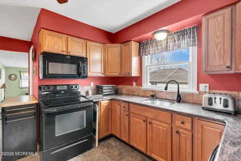 a kitchen with stainless steel appliances granite countertop a sink stove and microwave