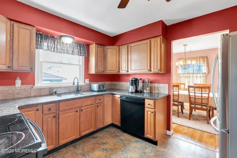 a kitchen with stainless steel appliances granite countertop a sink stove and wooden cabinets