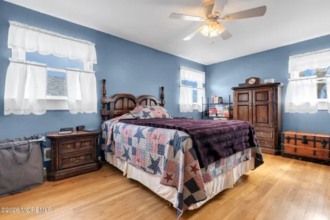a bedroom with a bed a dresser and a chandelier