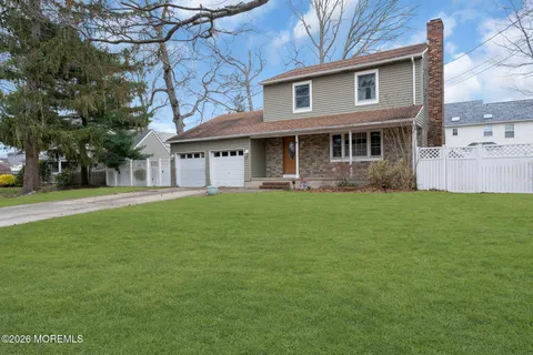 a front view of a house with a garden and trees