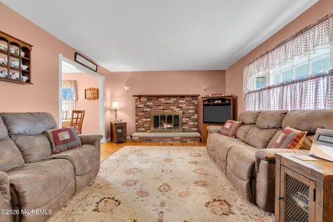 a living room with furniture a fireplace and a large window