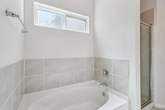 a white bath tub sitting next to a white sink and vanity