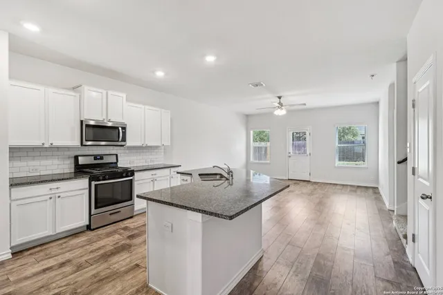 a kitchen with a sink stove and microwave