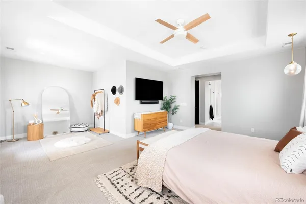 a bedroom with a bed a flat screen tv and a chandelier