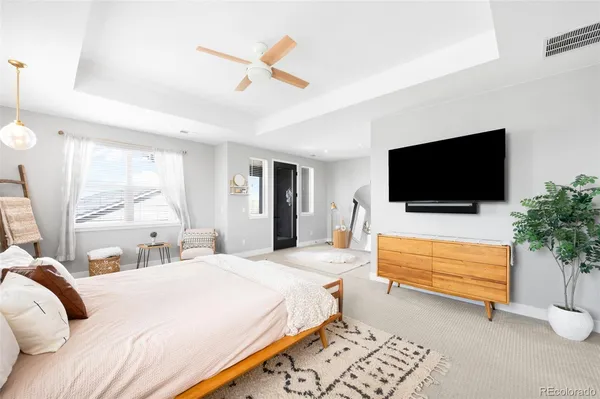 a bedroom with a bed a flat screen tv and a chandelier