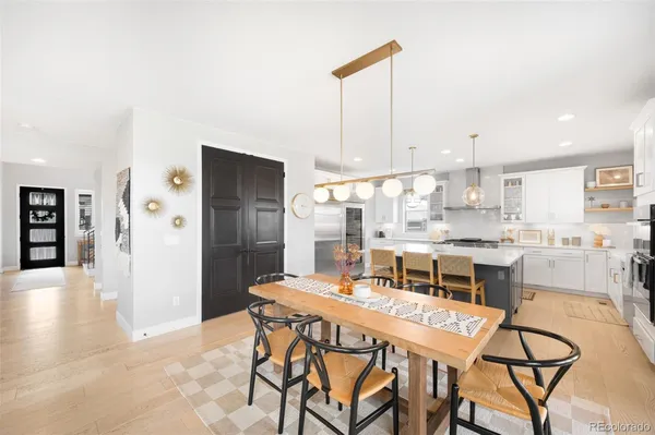 a dining area with a table chairs and a kitchen view