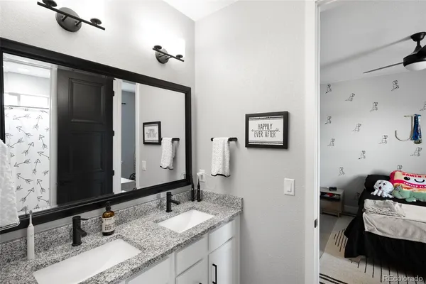 a bathroom with a granite countertop sink mirror and vanity