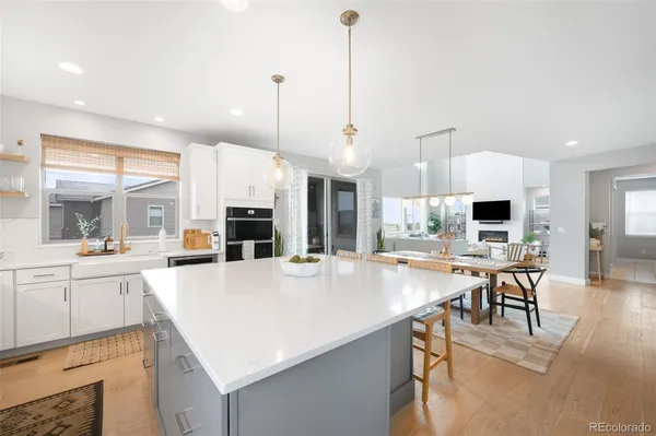 a large kitchen with kitchen island a stove a sink a dining table and chairs