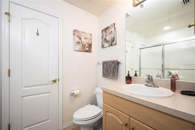 a bathroom with a toilet sink vanity and mirror