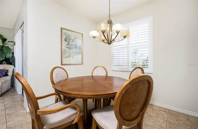 a dining room with furniture a chandelier and window